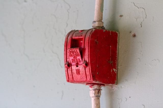 red fire alarm on a white wall